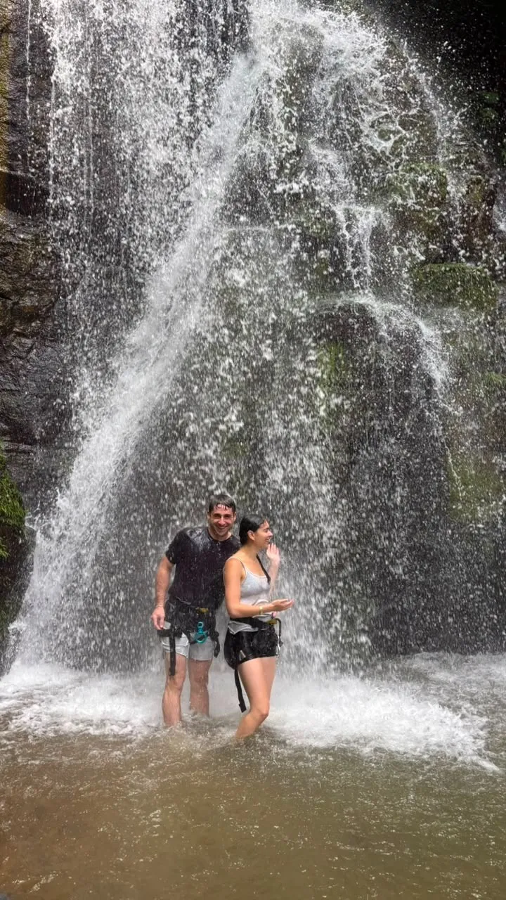 Visitantes bajo una catarata en la selva de Uvita